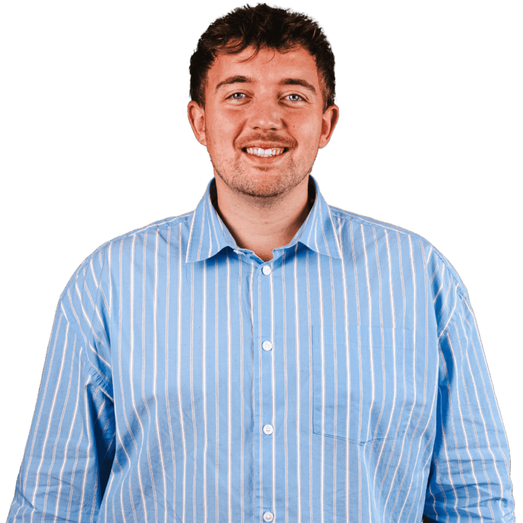 Mand i stribet skjorte smiler indendørs