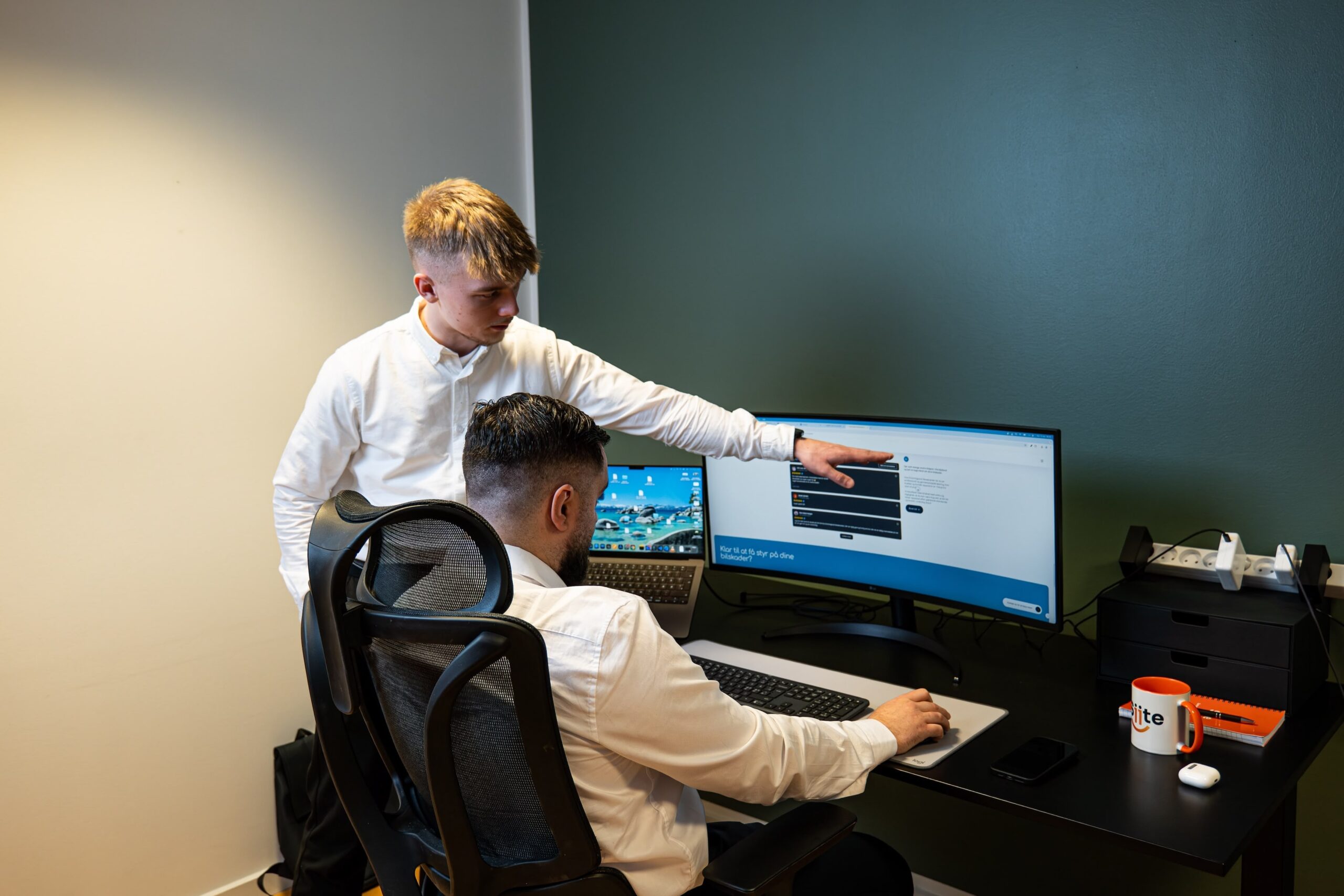 Dva muškarca rade na računaru u uredu.