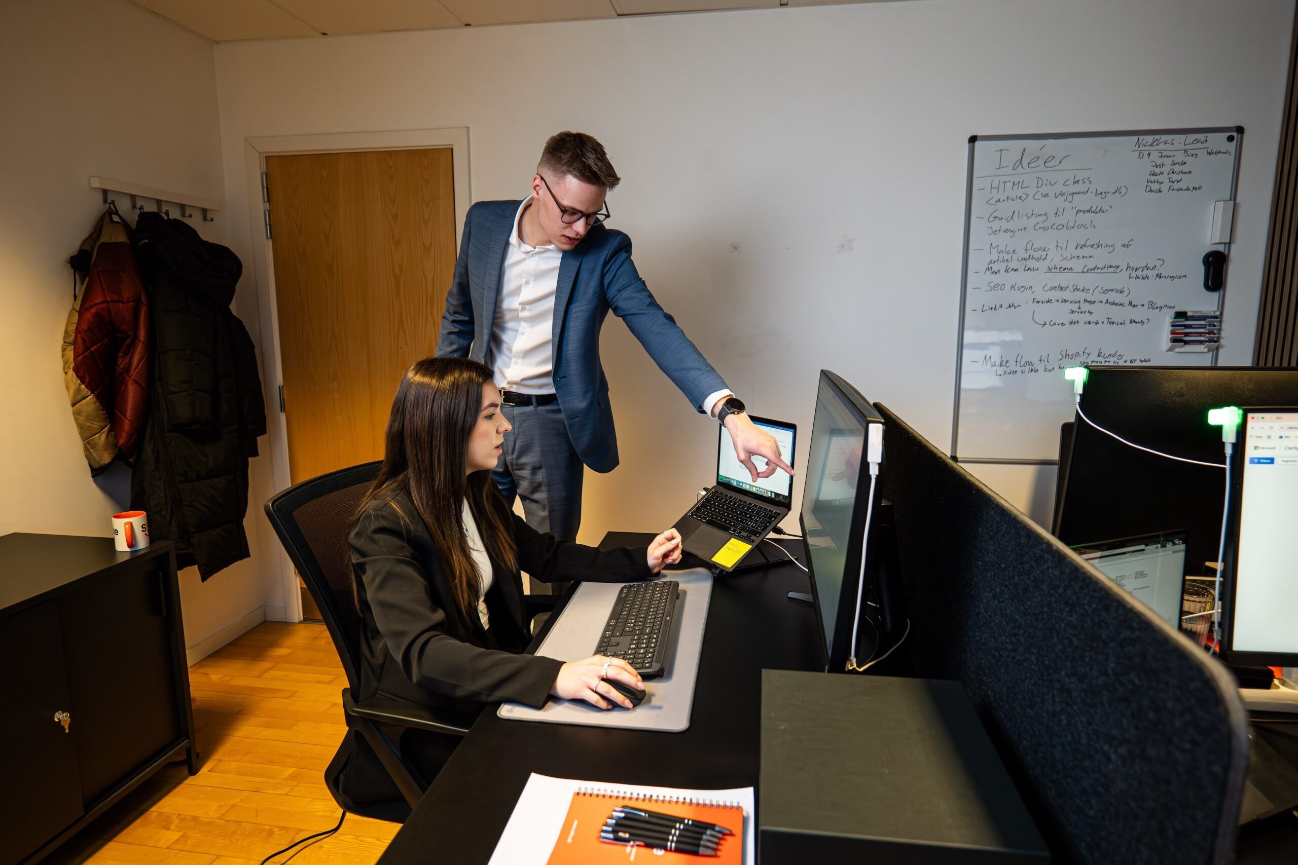 Uredski radnici sarađuju ispred računara.