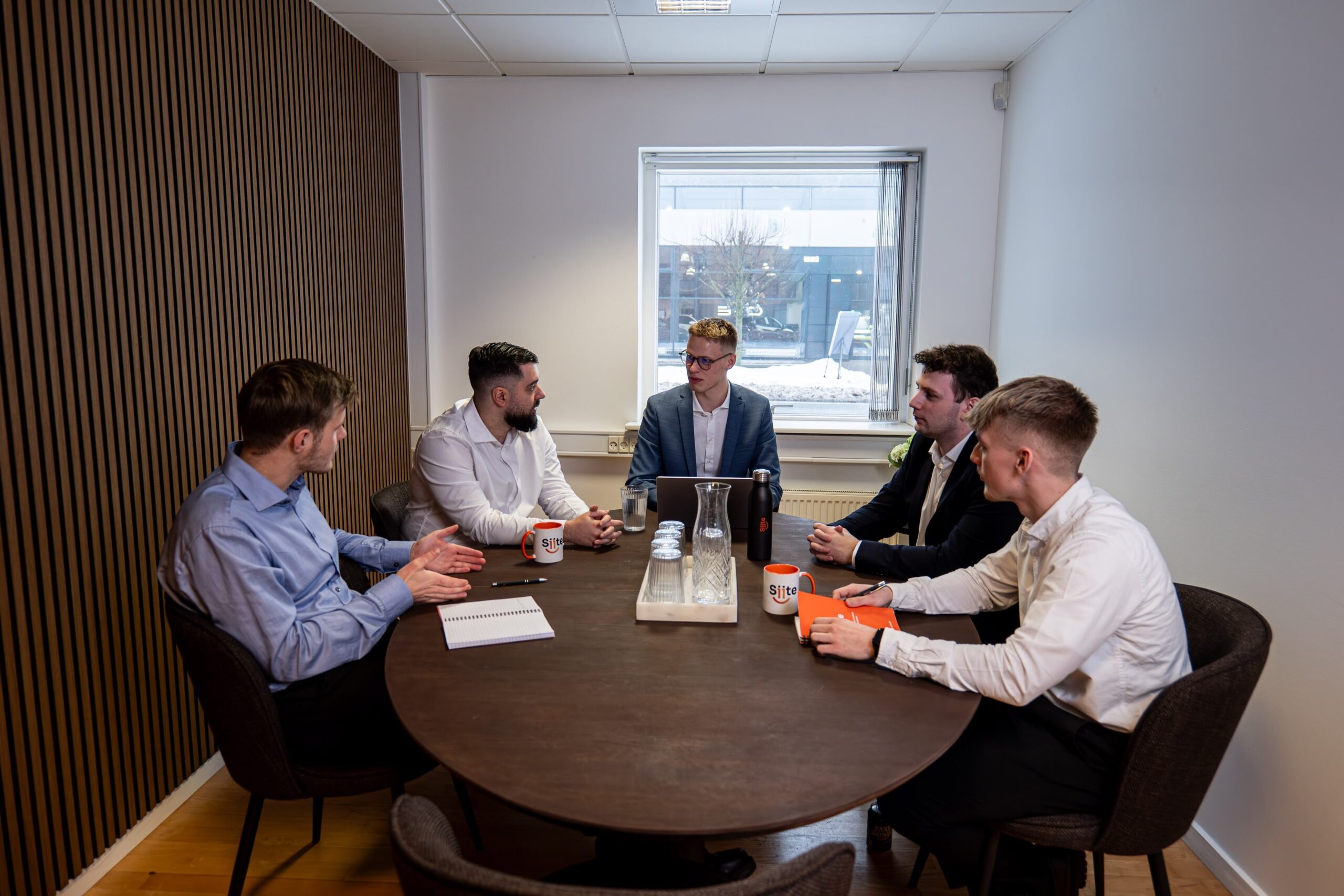 Sastanak u modernoj poslovnoj zgradi s pet osoba