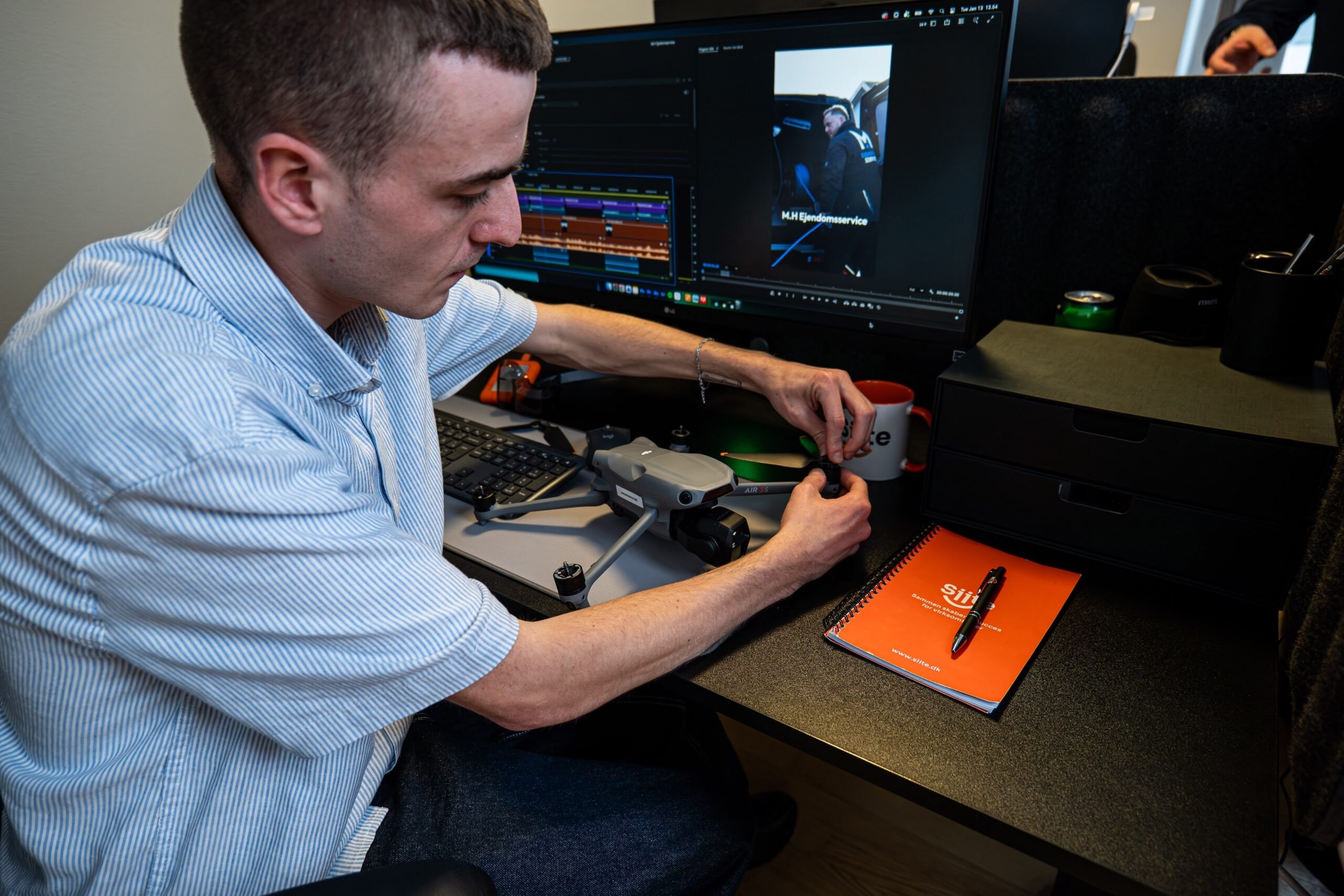 Mand podešava dron na stolu pomoću računara.